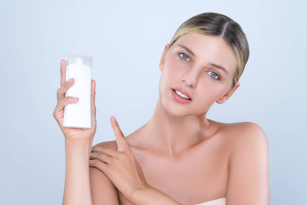 Intrygujący piękny idealny kosmetyk kobieta portret trzymać krem tubka makieta lub krem nawilżający do pielęgnacji skóry, anti-aging produktu w izolowanym tle. Naturalna koncepcja zdrowego modelu skóry. - Zdjęcie, obraz
