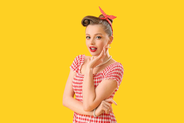 Young pin-up woman on yellow background - Fotoğraf, Görsel