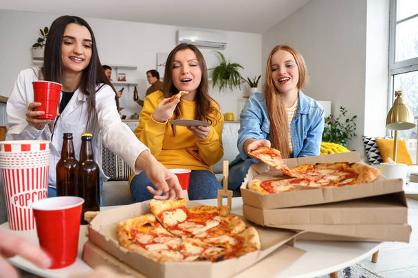 Группа друзей с вкусной пиццей и напитками дома - Фото, изображение