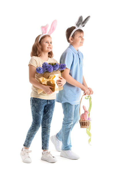 Маленькі діти в кролячих вухах з квітами та великодніми яйцями на білому тлі
 - Фото, зображення