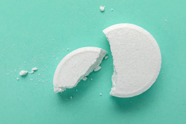Crushed white soluble tablet on turquoise background - Φωτογραφία, εικόνα
