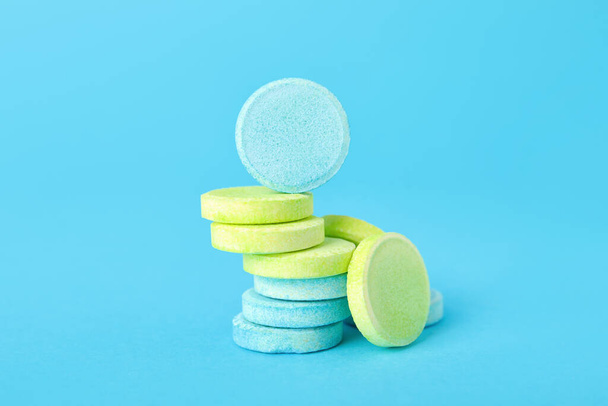 Pilha de comprimidos solúveis coloridos sobre fundo azul - Foto, Imagem