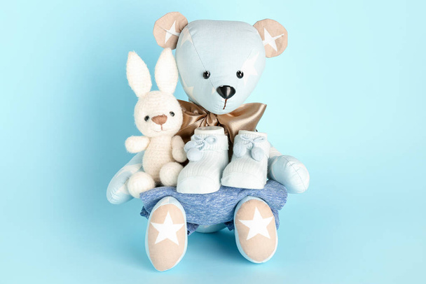 Brinquedo urso e coelho com roupas de bebê no fundo azul - Foto, Imagem