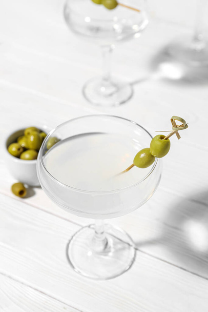 Стаканы мартини с оливками на белом деревянном фоне - Фото, изображение