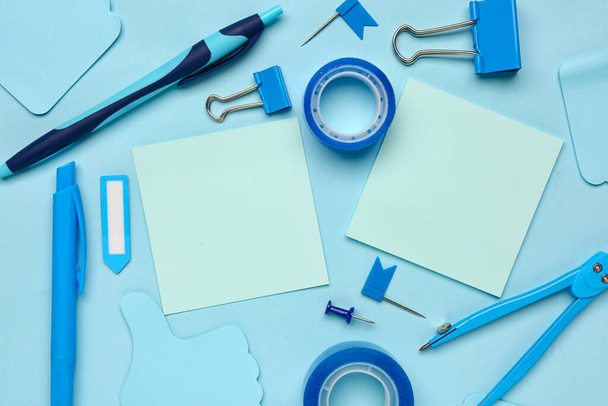 Composition with drawing compass, scotch tape and sticky notes on blue background - Photo, Image