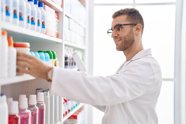 Young caucasian man pharmacist smiling confident prescription paper at pharmacy - Photo, Image