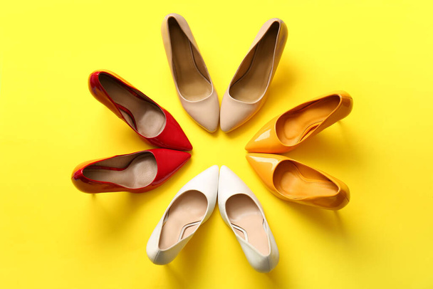 Fashionable high heeled shoes on yellow background - Fotoğraf, Görsel