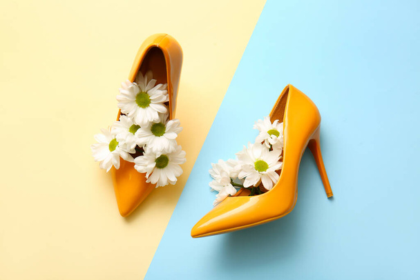 Pair of stylish high heeled shoes with flowers on color background - Foto, Imagem