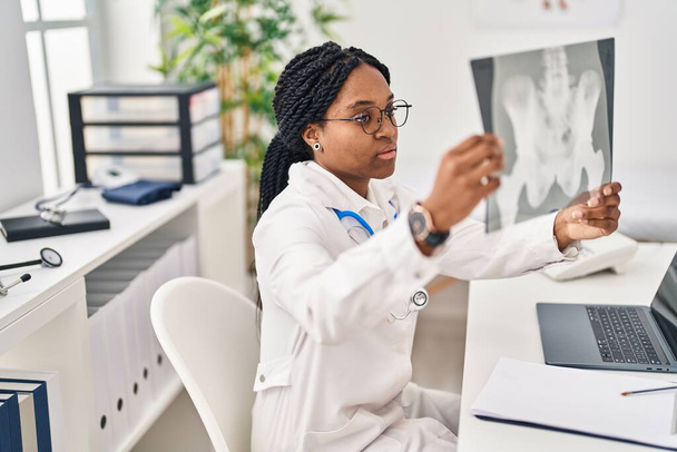 Αφροαμερικανή γιατρός ψάχνει ακτινογραφία κάθεται στο τραπέζι στην κλινική - Φωτογραφία, εικόνα