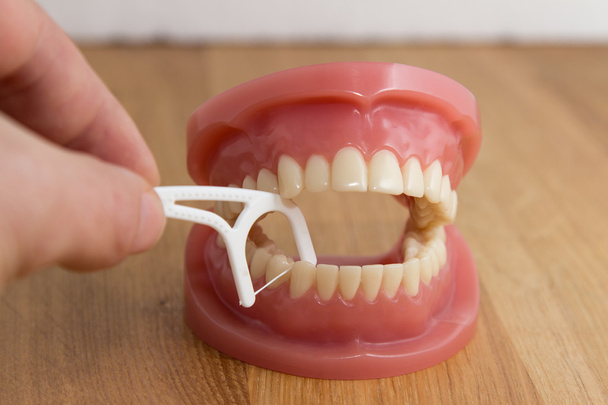 Człowiek do czyszczenia fałszywych zębów z nici dentystyczne - Zdjęcie, obraz