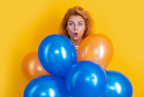 happy birthday girl hold balloons in studio. shocked girl with balloon for birthday party isolated on yellow background. birthday party girl. - Valokuva, kuva