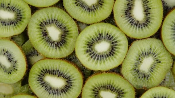 Zelené Kiwi plátky ovoce Pomalu rotující na černém pozadí. Čerstvé a šťavnaté - Záběry, video