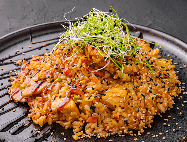chinese fried rice with chicken on black plate - Foto, Imagem