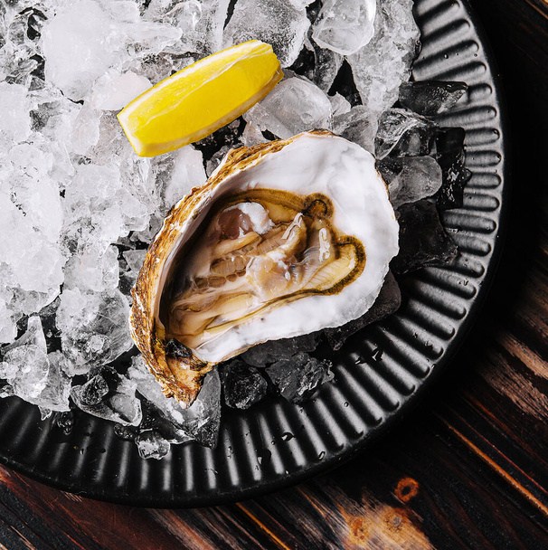 氷とレモンのスライスと新鮮な生牡蠣 - 写真・画像