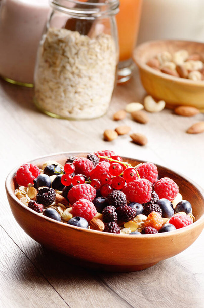Oatmeal oats with berries nuts orange juice and yogurt on wooden table - Фото, зображення