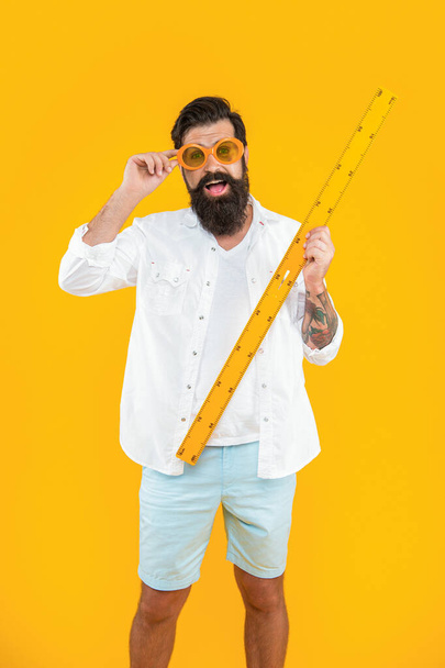 photo of amazed school man measure with ruler. school man measure with ruler isolated on yellow. school man measure with ruler in studio. school man measure with ruler on background. - Foto, immagini