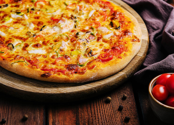 Deliciosa pizza con mariscos en soporte de madera - Foto, Imagen