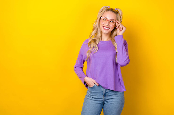 Photo of cheerful pretty woman wear violet shirt arm hand spectacles looking emtpy space isolated yellow color background. - Fotó, kép