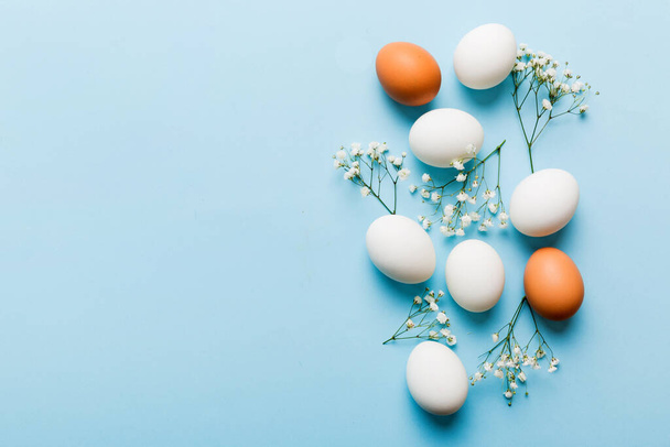 Happy Easter composition. Easter eggs on colored table with gypsophila. Natural dyed colorful eggs background top view with copy space. - Foto, Imagen