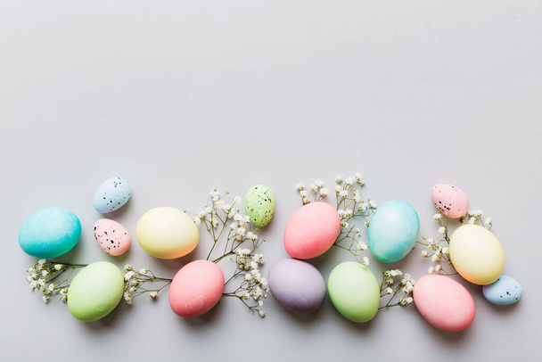 Feliz composición de Pascua. Huevos de Pascua sobre mesa de colores con gypsophila. Huevos coloridos teñidos naturales vista superior de fondo con espacio de copia. - Foto, imagen
