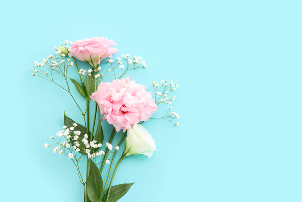 Top view image of delicate lisianthus flowers over pastel blue background - Foto, afbeelding