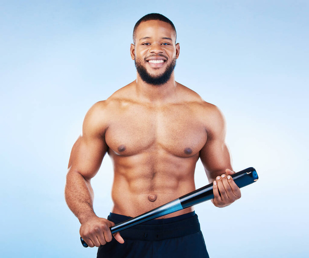 Black man, portrait and sports body with a baseball bat in studio for health, wellness and fitness. Face of healthy male aesthetic model with sport gear, strong muscle and smile on a blue background. - Photo, Image