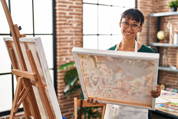 Mladá krásná hispánská žena umělec usmívá sebevědomě vypadající remíza na výtvarné studio - Fotografie, Obrázek