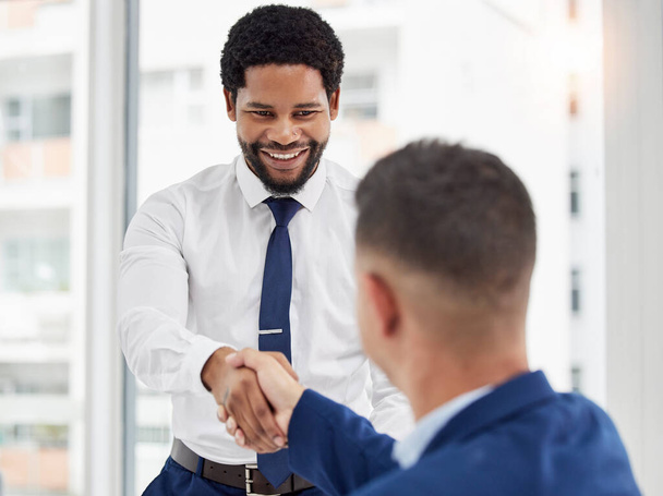 Businessman, handshake and meeting in partnership for deal, agreement or introduction at the office. Black man employee shaking hands with colleague for b2b, teamwork or collaboration at workplace. - Фото, зображення