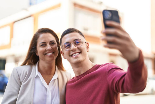 Man and woman mother and son smiling confident make selfie by the smartphone at street - Photo, image