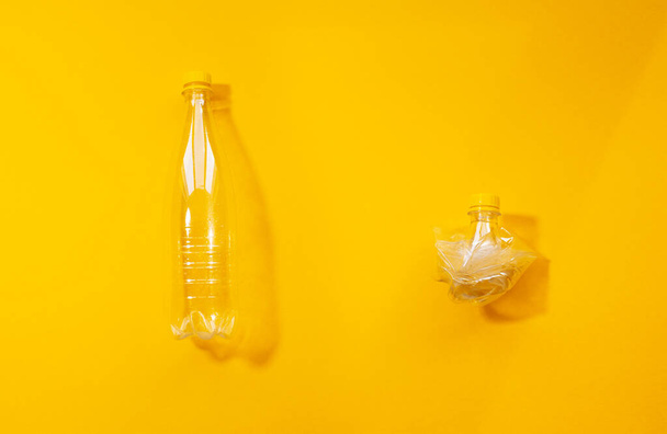 Zestaw dwóch pustych butelek plastikowych, pełnych i pogniecionych, kolaż izolowany na żółtym tle. - Zdjęcie, obraz