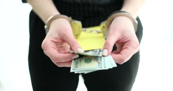 Vrouw met handboeien toont envelop met geld contant geld in de lichte kamer. Persoon gearresteerd voor financiële misdaden met bewijzen. Criminele reacties voor steekpenningen eisen - Video