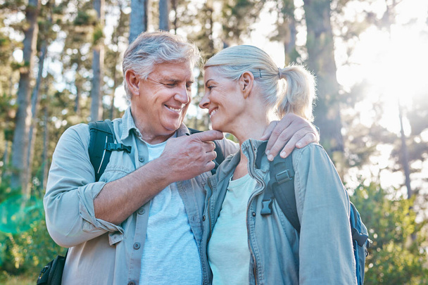 Love, nature and senior couple on a hike together in a forest while on outdoor weekend trip. Happy, intimate moment and elderly man and woman in retirement trekking in woods to explore and adventure - Foto, imagen