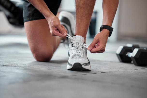 Fitness, hands and tie shoes in gym to start workout, training or exercise. Sports, athlete and man tying footwear or sneakers to get ready or prepare for running, cardio or exercising for health - Foto, Imagem