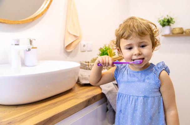 The child brushes his teeth in the bathroom. Selective focus. Nature. - Foto, imagen