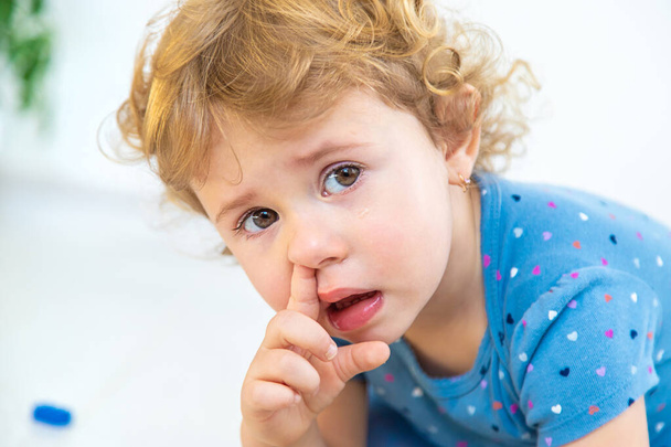 The child sticks his finger in his nose. Selective focus. Kid. - Fotó, kép