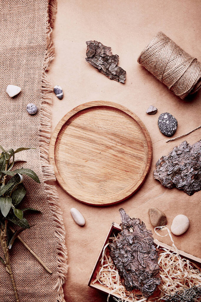 Sustainable, eco-friendly lifestyle. Natural wooden mock up - template tray among tree bark, green leaves, pebbles, cotton thread. - Fotó, kép