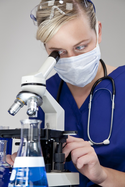 Beautiful Blond Doctor or Scientist Using Microscope In A Labora - Foto, imagen