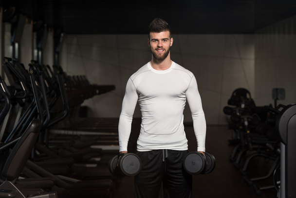 Young Man Exercising Biceps With Dumbbells - Foto, afbeelding