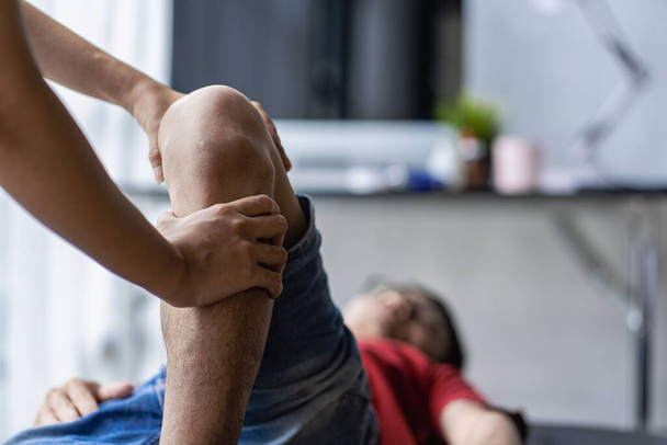Junger asiatischer Mann macht Physiotherapie und sucht Rat bei Muskelschmerzen mit Schulter, Gliedmaßen im Reha-Zentrum. - Foto, Bild