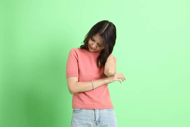 The young adult Asian woman with casual clothes with jeans standing on the green background. - Foto, afbeelding