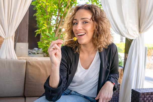 Schöne junge Frau genießt einen Snack in einem Restaurant im Freien - Foto, Bild