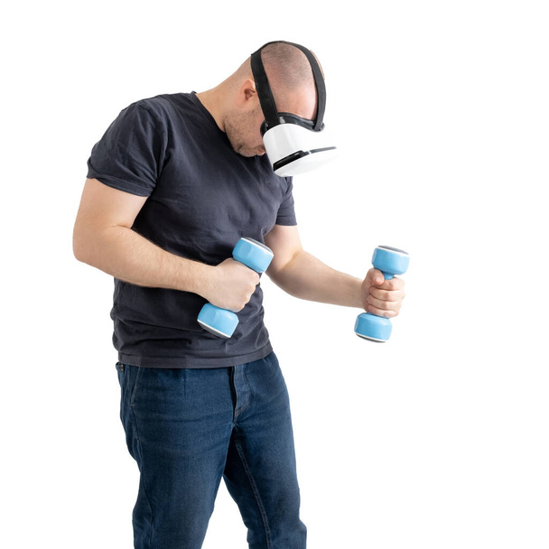 Unsportsmanlike middle-aged man wearing virtual reality glasses with dumbbells. Isolated on a white background. - Fotó, kép