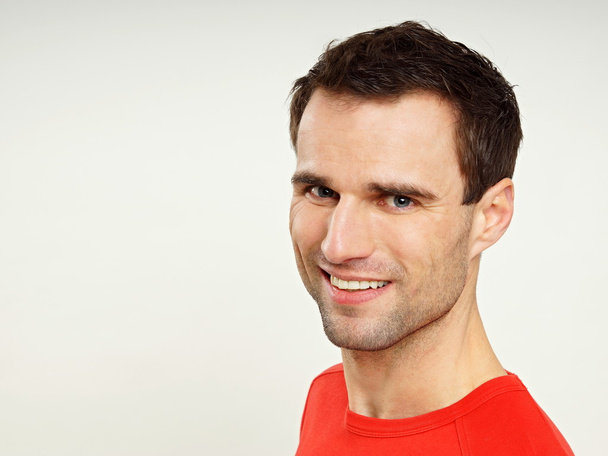 Усміхнений молодий чоловік у червоній сорочці
 - Фото, зображення
