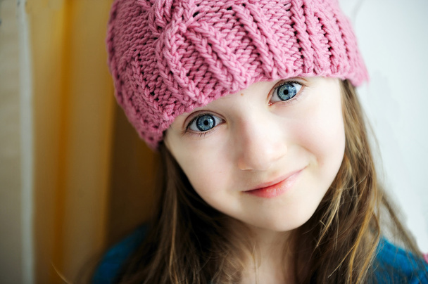 Adorable smiling child girl in pink knitted hat - Foto, imagen