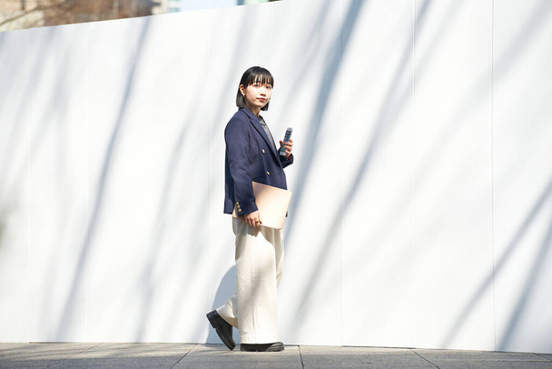 женщина держит смартфон на улице - Фото, изображение