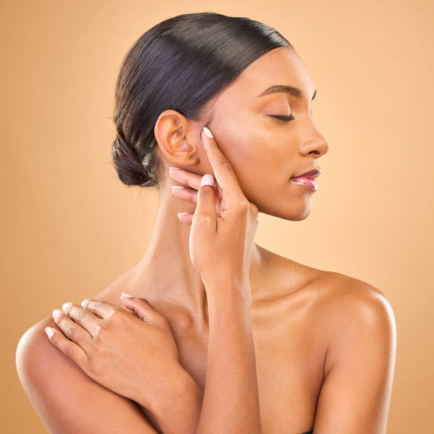Beauty, face profile and skin of woman in studio for skincare, cosmetics, dermatology or makeup. Aesthetic female model .hands for natural self care and spa facial shine results on a brown background. - Fotoğraf, Görsel