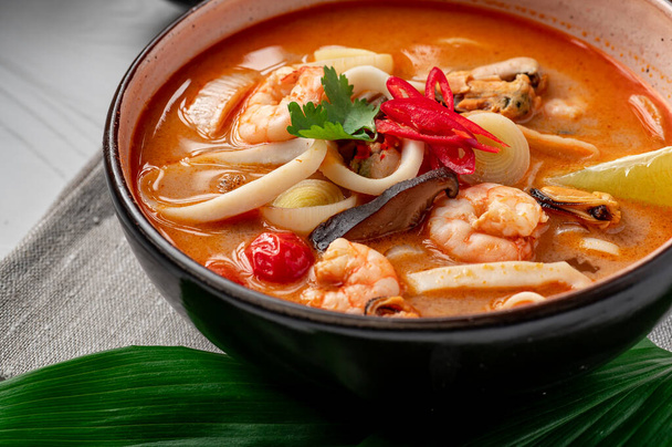 Soupe de tom yum asiatique épicée aux crevettes, calmars, moules et légumes. Cuisine asiatique. Une nourriture délicieuse et saine. Photo pour le menu. - Photo, image