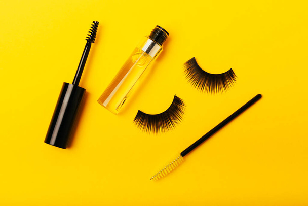 Gel for the growth of eyelashes and eyebrows. Serums, essential oils or essences for eyelash growth with a strong effect on a yellow background. Place for text. Place to copy. MOCKUP - Photo, Image
