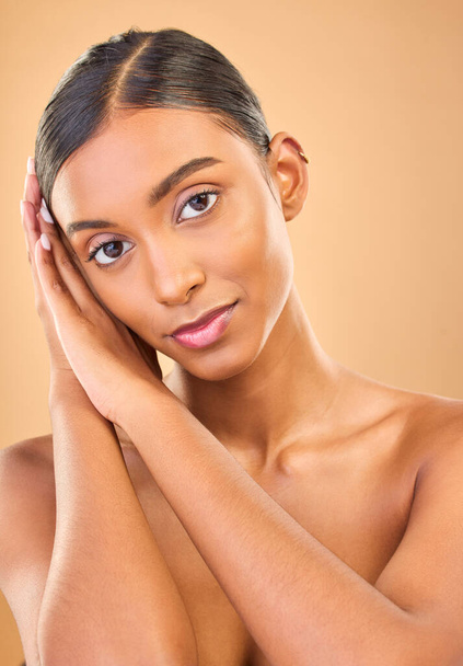 Portret twarzy, pielęgnacja skóry i piękno kobiety w studiu odizolowane na brązowym tle. Makijaż, naturalne kosmetyki i poważny indyjski model żeński z zabiegiem uzdrowiskowym twarzy dla skóry zdrowej lub bez skazy - Zdjęcie, obraz