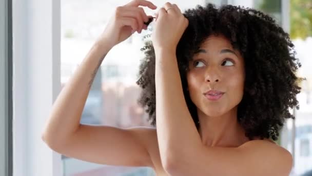 Zwarte vrouw, natuurlijk haar en schoonheid, terwijl je je klaar en gelukkig voelen over haarverzorging, groei en afro krullen in huis badkamer. Gezicht portret van een Afrikaans model tijdens de ochtend zelfverzorging routine. - Video